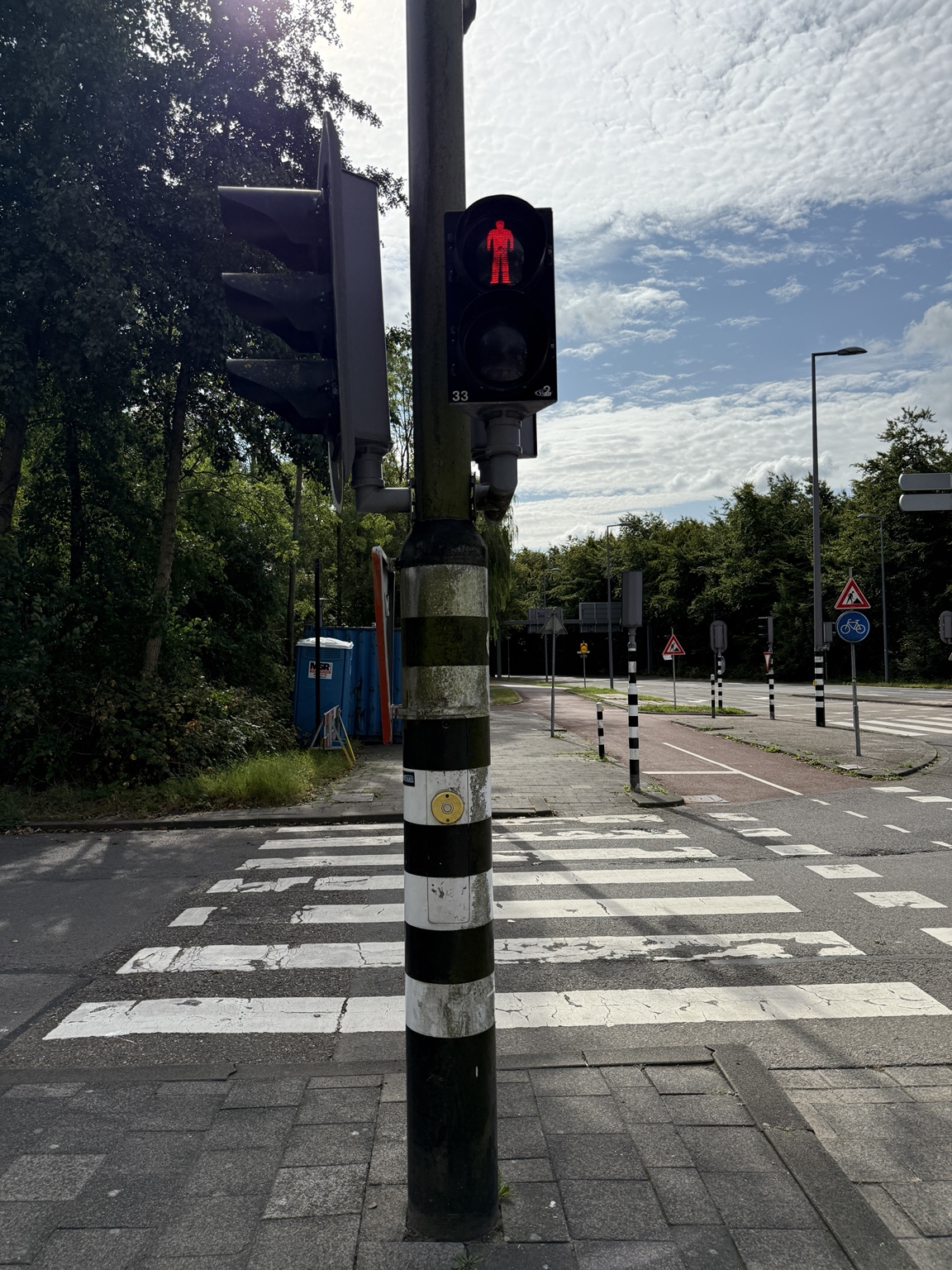Verkeerslichtmast vóór het schilderen met vervuilde zwart-witte banden